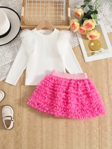 Flat lay of girl's white ribbed long sleeve top and pink tiered mesh tutu skirt set