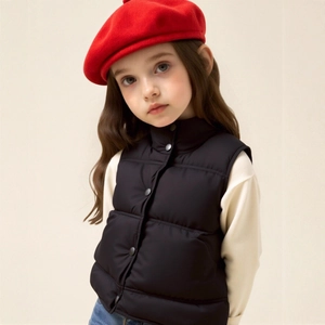 Close-up of kids black puffer vest with stand collar and snap button closure