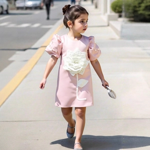 Detail of pink flower girl dress with 3D rose applique and pearl puff sleeves