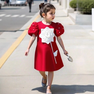 Detail of red girl dress featuring puff sleeves with pearls and 3D white rose applique