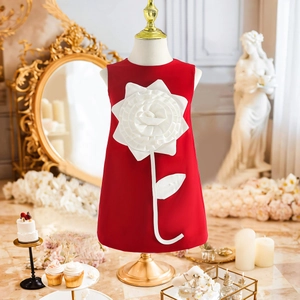 Close-up of red girls' formal dress featuring a large white 3D floral applique on the front