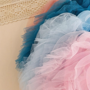 Detailed view of multilayered colorful tulle fabric with delicate crochet lace accent