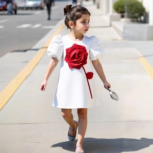 Detail of white flower girl dress featuring large 3D red roses and puff sleeves