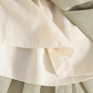 Détail de couches de tissu plissé avec couture surjetée soignée sur la doublure intérieure