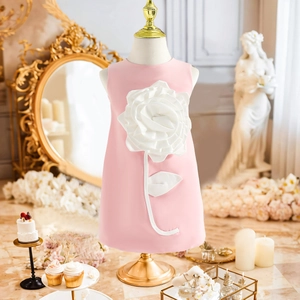 Detail of a pink sleeveless girls' dress featuring a large 3D white rose floral applique