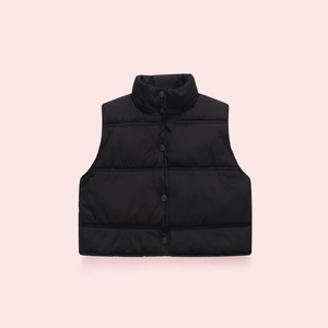 Detail view of black quilted puffer vest with snap button closure and stand collar
