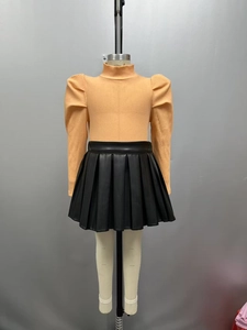 Détail du haut à manches longues côtelé orange pour fille avec jupe plissée en similicuir