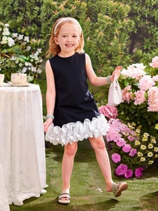 Elegant sleeveless girl dress in navy blue with layered white ruffled skirt in garden