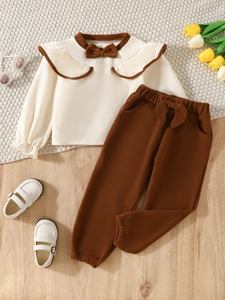 Girls 2-piece autumn set featuring beige ruffle top with bow and brown joggers