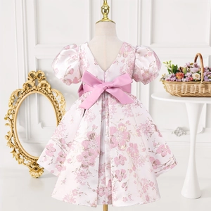 Vue arrière d'une robe de princesse rose avec manches bouffantes, grand nœud et jacquard