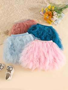Colorful multi-layered tutu skirts for kids in pink and blue on a warm background