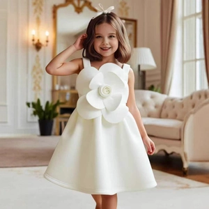 Dettaglio di abito bianco senza maniche per bambina con fiori 3D e balze eleganti