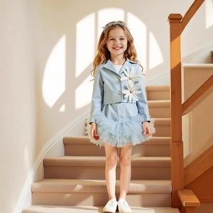 Detail of girls light blue suit with large floral appliques and lace ruffled skirt hem