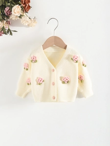 Cream knit cardigan for girls featuring 3D pink crochet flowers and matching buttons