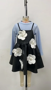 Détail de fleurs 3D avec perles sur la robe en similicuir noir et haut bleu