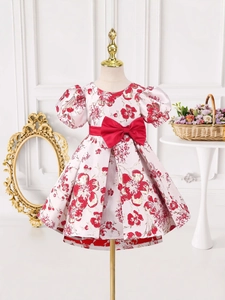Robe de princesse à fleurs avec manches bouffantes et ceinture à nœud rouge sur mannequin