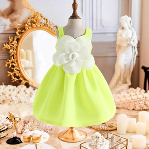 Dettaglio dell'abito da bambina verde neon con grande fiore 3D bianco e volant chic