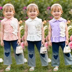 Detail von Mädchen-Outfit mit 3D-Blumen-Top und Jeans mit Herz-Applikation