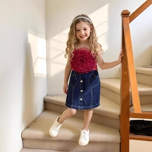 Détail de l'ensemble fille avec haut rouge à fleur 3D et jupe en jean à poches cœur