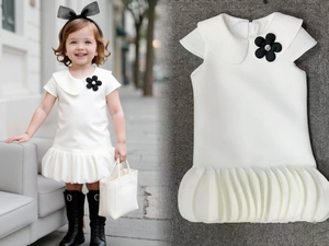 Detail of white puff sleeve girl's dress with Peter Pan collar and black flower decor