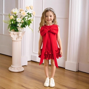 Detail of red sleeveless girls' dress featuring a large bow and layered ruffle hem