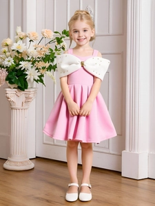 Elegant pink sleeveless girl's dress with large white bow and pleated skirt for parties