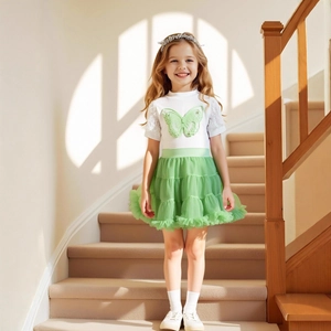Détails du t-shirt blanc en dentelle et de la jupe tutu en tulle vert pastel