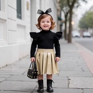 Detail of girl's knit top with ruffles and pleated leather skirt on outdoor street