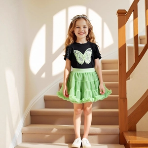 Détail du t-shirt papillon noir et de la jupe tutu verte à volants pour filles