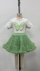 Détail du t-shirt papillon blanc avec manches à plumes et jupe tutu en tulle vert à volants