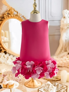 Detailed view of 3D layered rose petals on the skirt of a fuchsia princess dress