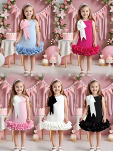 Detail of multi-color girls party dresses with oversized bows and layered ruffled skirts