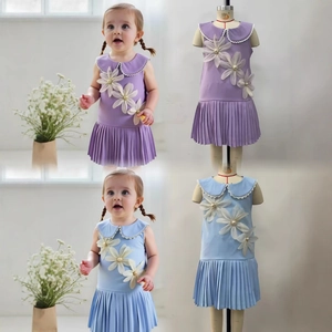 Detail of girls' pleated sleeveless dress featuring lace Peter Pan collar and 3D floral appliques