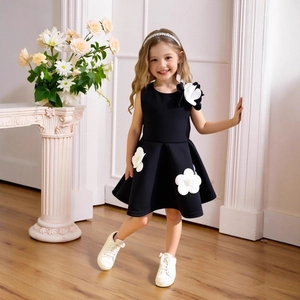 Détail d'une robe noire sans manches pour filles avec d'élégantes fleurs blanches en 3D