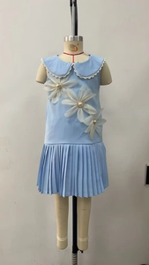 Detail of light blue girls' pleated dress with 3D mesh flowers and pearl accents