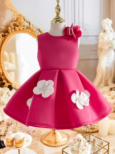Détails d'une robe rose de soirée avec pétales 3D et perles sur un mannequin doré élégant