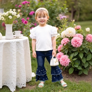 Detail of girls' waffle puff sleeve top and flared denim pants with pearl fringe