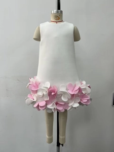 Detail of white sleeveless princess dress featuring 3D floral petals on the skirt hem