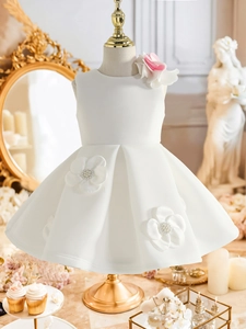 Détail d'une robe de soirée blanche en satin avec fleurs 3D et jupe plissée élégante