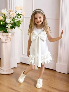 Elegant white sleeveless girls party dress with oversized bow and tiered ruffle skirt