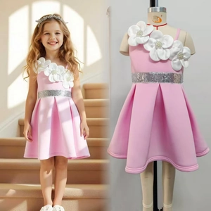 Detail of pink one-shoulder girl's dress with 3D floral petals and silver sequin belt