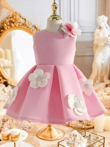 Détail d'une robe de princesse rose avec fleurs 3D et décorations de perles