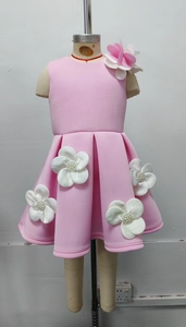 Détail d'une robe rose pour fille avec appliques florales 3D et perles sur l'épaule