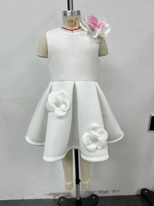 Détail de la fleur 3D sur l'épaule et accents de perles sur robe de soirée blanche fille