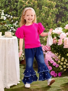 Girls fashion set with hot pink puff sleeve top and pearl-studded flare jeans in garden