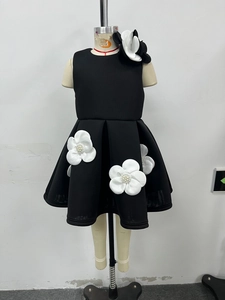 Détail de robe enfant avec fleurs 3D et perles sur tissu noir sans manches élégant