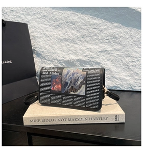 Detail view of the vintage newspaper and oil painting print on this black crossbody bag