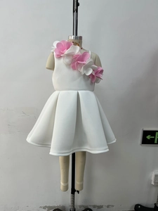 Detail of 3D pink and white handmade flowers on a white girls' sleeveless party dress