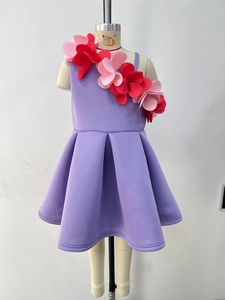Detailed view of handmade 3D floral accents on a lilac girl's one-shoulder party dress