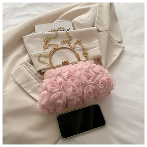 Détail des pétales de rose rose 3D et de l'anse en métal doré de la pochette de soirée